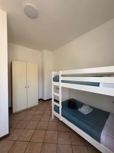 a bedroom with two bunk beds and a tiled floor at Casa Chiara in Mandello del Lario