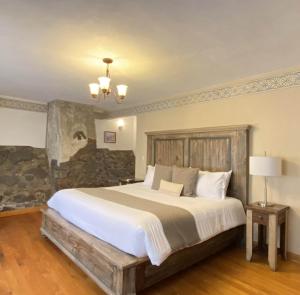 a bedroom with a large bed and a stone wall at Hacienda Soltepec Suites Campo de Golf in Huamantla +31 photos