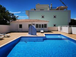 a swimming pool in front of a house at Cabanas Family Apartment in Cabanas de Tavira