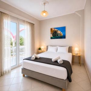 a bedroom with a large bed and a large window at Villa Joanna in Vasilikos