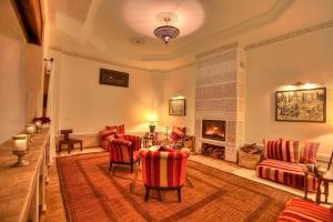 a living room with red chairs and a fireplace at Riad le Clos des Arts in Marrakech