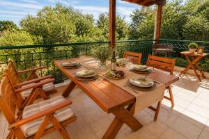 a wooden table and chairs sitting on a patio at E&M Villa Sea View II in Polychrono
