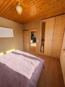 a bedroom with a bed and a wooden ceiling at Das Haus am See - der idyllische Privatsee nahe Wien in Tulln