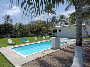 a swimming pool with two chairs and a house at Finca la Esperanza in Guadalupe