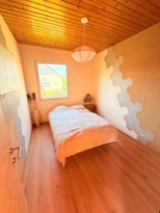 a bedroom with a bed in a room with a window at Das Haus am See - der idyllische Privatsee nahe Wien in Tulln
