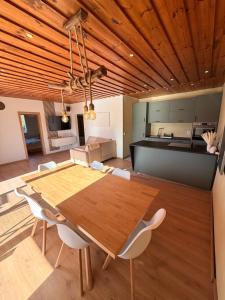 a kitchen and dining room with a wooden table and chairs at Das Haus am See - der idyllische Privatsee nahe Wien in Tulln