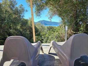 a pair of white chairs sitting on a patio with a view at Yourte Corsica vera in Appietto