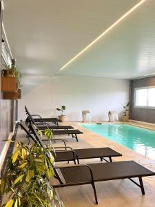 a pool with a row of chairs and a swimming pool at Alamo Hotel in Villa Carlos Paz