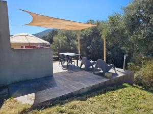 a patio with a table and chairs under a canopy at Yourte Corsica vera in Appietto