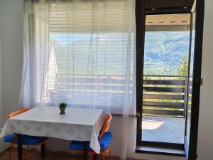a white table with chairs and a large window at Monolocale Belvedere in Bovec