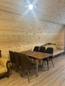 a dining room with a table and chairs and a couch at Sisters House in Borjomi