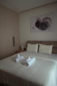 ein Schlafzimmer mit einem Bett, auf dem zwei Handtücher liegen in der Unterkunft Chōros in Larisa
