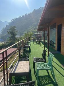 a row of benches sitting on a balcony with a mountain at LA Foresta resort by Utopia in Shivpuri