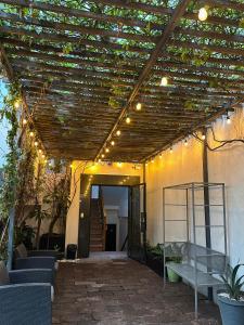 a patio with a wooden pergola with lights on it at MRE Goldsmith Polanco in Mexico City