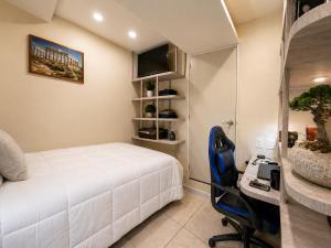 a bedroom with a bed and a desk with a computer at Habitación individual con baño privado a 3 Min del Estadio Azteca-Banorte y muy cerca de zona de hospitales in Mexico City