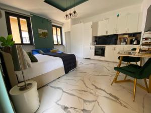 a bedroom with a bed and a table and a kitchen at Leo&Franci Loft in Legnano