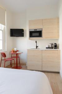 a kitchen with wooden cabinets and a table with a tableablish at Check In Belfast in Belfast