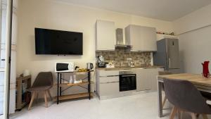a kitchen with a table and a television on the wall at La casa dei desideri in Pizzo