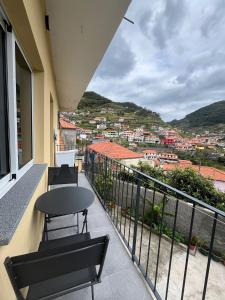 a balcony with a table and chairs and a view at Cozy Noia in Machico