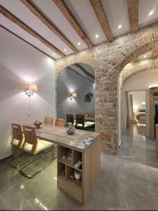a dining room with a stone wall and a table and chairs at Dalti Center Apartment in Zadar