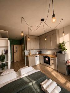 a kitchen with white cabinets and white towels on the floor at MIŁO Apartament Zarembowicza in Wrocław