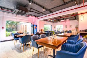 a restaurant with wooden tables and blue chairs at The Zean Luxury in Jāmb