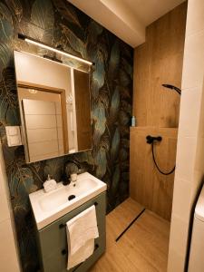 a bathroom with a sink and a shower at MIŁO Apartament Zarembowicza in Wrocław