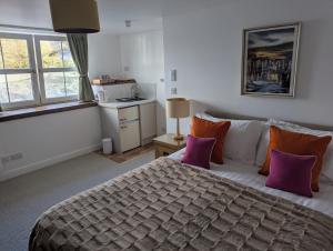 a bedroom with a large bed with purple and orange pillows at Ladysmith Guest House in Ullapool