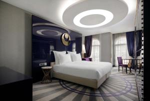 ein Schlafzimmer mit einem großen weißen Bett und einer Decke in der Unterkunft Sura Design Hotel & Suites in Istanbul