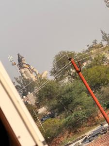 a large statue in the background with a building at Sunrise stay in Chhatikara