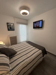 a bedroom with a bed and a tv on the wall at Apartment zona Naturista in Vera