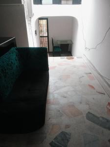 a black couch sitting in a room with a tile floor at Alojamiento RUBY'S in Pereira
