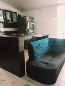 a kitchen with a couch and a counter with a stove at Alojamiento RUBY'S in Pereira