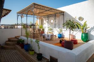 a patio with a table and potted plants at Riad Rita in Meknès