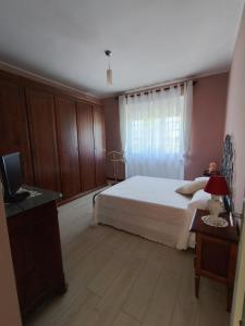 a bedroom with a white bed and a window at I Quattro Venti in Pralormo