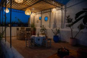 a patio with a table and chairs and lights at Riad Rita in Meknès