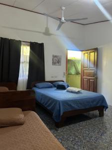 a bedroom with two beds and a ceiling fan at Restaurante y cabinas Sudy in Carara +51 photos