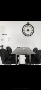 a table with chairs and a clock on a wall at דירה על הים in Ashdod