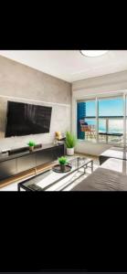 a living room with a large tv and a couch at דירה על הים in Ashdod
