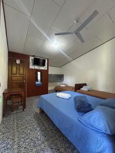 a bedroom with a bed and a ceiling fan at Restaurante y cabinas Sudy in Carara
