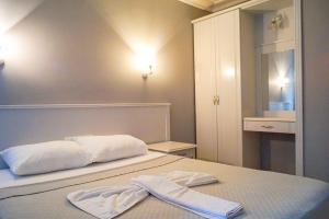 a bedroom with a bed with two towels on it at Adora Pansiyon in Side
