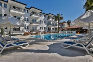 a swimming pool with lounge chairs and a hotel at Adora Pansiyon in Side