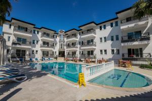 a large apartment building with a large swimming pool at Adora Pansiyon in Side