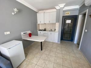 a kitchen with white cabinets and a white refrigerator at Adora Pansiyon in Side