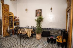 a living room with a table and a fireplace at Riad Rita in Meknès