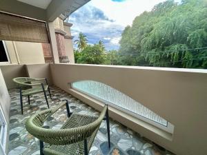 a balcony with two chairs and a bench on a balcony at Serenity villa in Pointe aux Biches