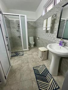 a bathroom with a sink and a shower and a toilet at Serenity villa in Pointe aux Biches