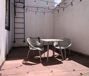 a table and two chairs in a room with lights at MRE Goldsmith Polanco in Mexico City