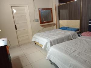 a bedroom with two beds and a window and a door at Departamento Luque in Luque