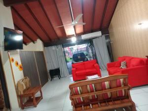 a living room with red furniture and a ceiling fan at Departamento Luque in Luque